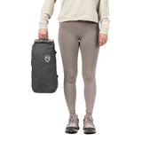 NEMO Satellite reclining chair carry bag in dark grey, held beside a person's leg