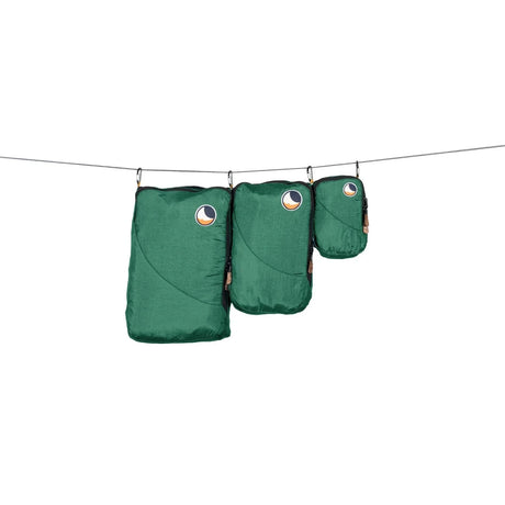 Three green Ticket to the Moon packing cubes of different sizes hanging from clips on a line